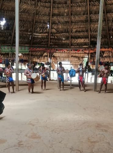 Embera musicians playing traditional handmade drums and bamboo flutes in Panama.