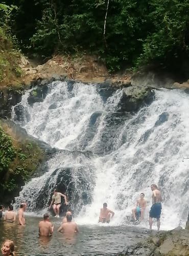 Travelers swimming in a natural waterfall during the Embera village day trip in Panama.